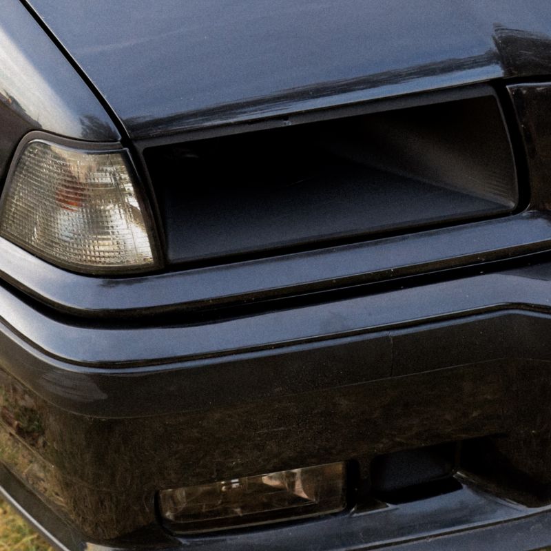 BMW E36 Headlight Air Intake installed, angled close-up view
